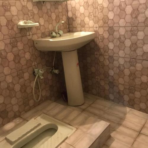 a bathroom with a sink and a toilet in the floor at ViveGee Cottage Khanipur Ayubia in Ayubia
