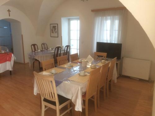uma sala de jantar com uma mesa longa e cadeiras em Haus zum Nibelungenlied em Melk
