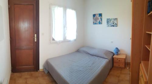 - une chambre avec un lit, une fenêtre et une porte dans l'établissement T2 Lava Plage, à Appietto