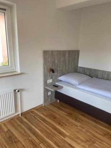 ein kleines Schlafzimmer mit einem Bett und einem Fenster in der Unterkunft Boardinghouse-Heuchelhof in Würzburg