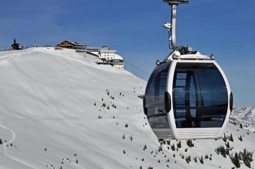 a ski lift going up a snow covered slope at Dahoam by Sarina - Village Appartements in Zell am See