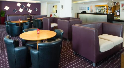 a restaurant with tables and chairs and a bar at Holiday Inn Express Hemel Hempstead by IHG in Hemel Hempstead