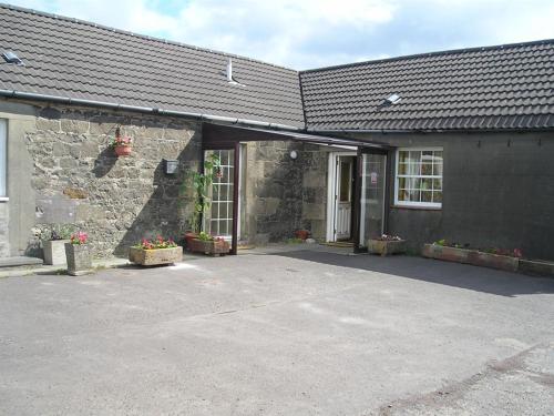 a building with a parking lot in front of it at Blairmains Guest House in Kirk of Shotts