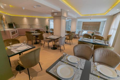 a restaurant with tables and chairs and a kitchen at Imperial Boutique Hotel Rabat in Rabat