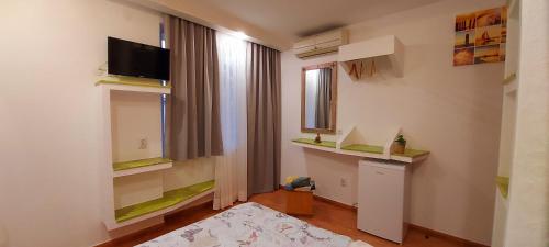 a room with a bed and a tv and a window at Sentosa ROOM in Nesebar