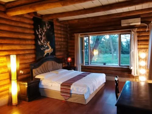 Dormitorio con cama y ventana en una cabaña de madera en 北戴河海边森林木屋别墅, en Qinhuangdao