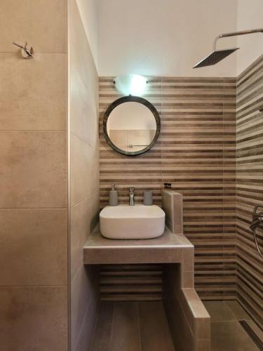 a bathroom with a sink and a mirror at Irida Studios in Agios Ioannis Pelio
