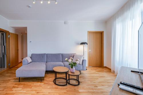 a living room with a blue couch and a table at Artisa Riia Str 22A Luxury apartment in Tartu