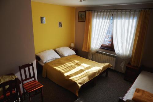 a bedroom with a bed and a chair at Łapszańska Ostoja in Łapsze Niżne