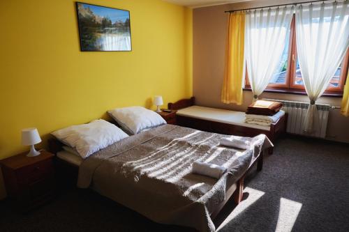 En eller flere senge i et værelse på Łapszańska Ostoja