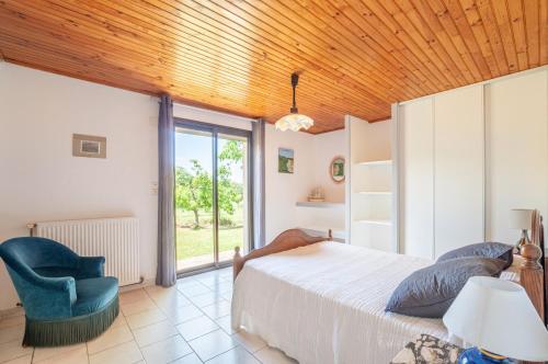 - une chambre avec un lit et une chaise bleue dans l'établissement Gîte Laulerie, à Saint-Méard-de-Gurçon