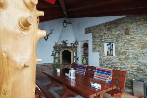 a dining room with a wooden table and a stone wall at Łapszańska Ostoja in Łapsze Niżne