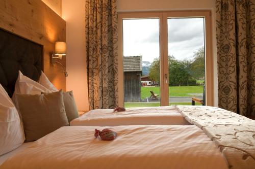 two beds in a hotel room with a window at Villa Alpin in Holzgau