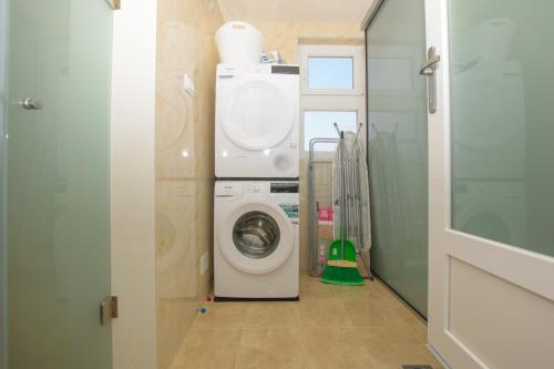 a laundry room with a washer and a washing machine at Relaxing villa Mala vala in Fažana