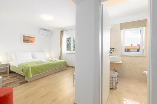 a small bedroom with a bed and a bathroom at Relaxing villa Mala vala in Fažana