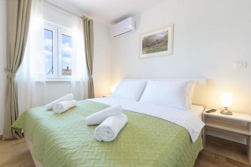 a bedroom with a large bed with towels on it at Relaxing villa Mala vala in Fažana