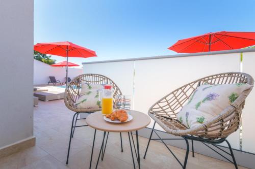 two chairs and a table with a glass of orange juice at Relaxing villa Mala vala in Fažana