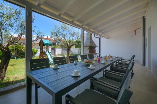 a blue table and chairs on a patio at Relaxing villa Mala vala in Fažana