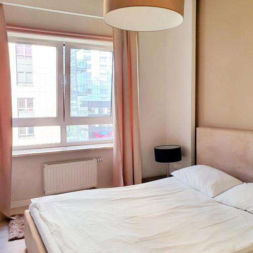 a bedroom with a white bed and a window at Chopin Apartments - Platinum Towers in Warsaw