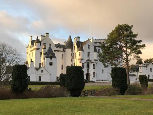 un gran castillo blanco con un árbol en el primer plano en Dalgreine Guest House, en Blair Atholl