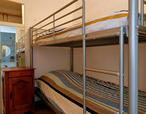 quelques lits superposés dans une chambre dans l'établissement Charmant Appartement vue PORT DE GRUISSAN 5DROM44K, à Gruissan