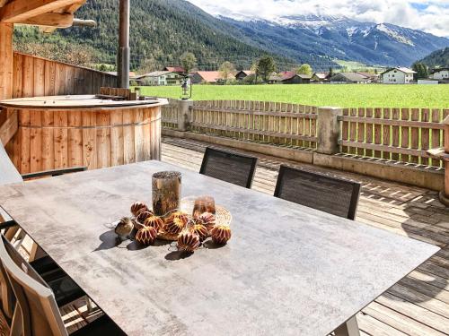 a table on a deck with a view of a mountain at Luxury Chalets Wiesenruh in Bichlbach