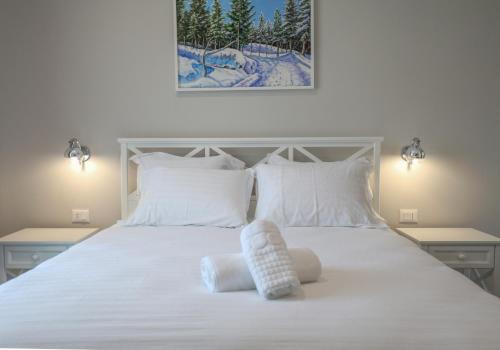 una camera da letto con un letto bianco con due asciugamani di Hotel Peroni a Korçë