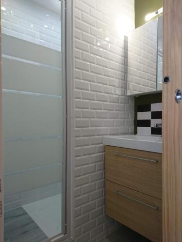 une salle de bain avec une douche en verre et un lavabo dans l'établissement La Croisette, à Mont-de-Lans