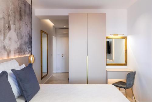 a bedroom with a white bed and a chair at Villa Leoni in Dubrovnik
