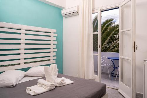 una camera da letto con un letto e asciugamani bianchi di Ikaros a Karterados