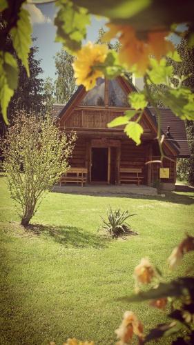 a log cabin with a green yard with yellow flowers at U Leona in Gorlice