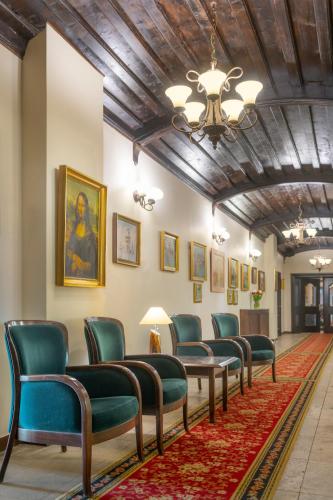a waiting room with green chairs and a ceiling at Hotel Mona Lisa Wellness & Spa in Kołobrzeg