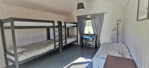 a bedroom with two bunk beds and a desk at Campsite Ģirti in Bernāti