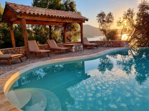 a swimming pool with a gazebo and a table and chairs at Villa Nautique - Waterfront in Sivota