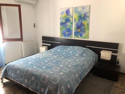 a bedroom with a bed and two paintings on the wall at La Sirena in Les tres Cales