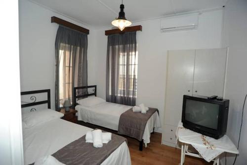 una camera d'albergo con due letti e una televisione di CRECIAN WATER FRONT a Egira