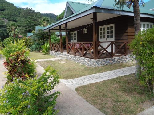 a house with a porch and a pathway leading to it at Chez Michellin Pensions Residence in La Digue