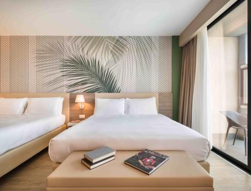 ペスキエーラ・デル・ガルダにあるエンジョイ ガルダ ホテルのベッドルーム1室(ベッド2台、テーブル、本付)