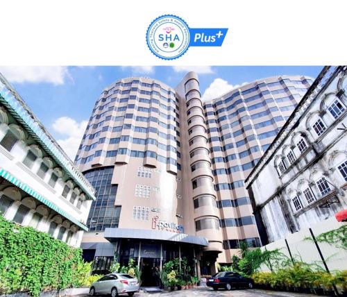 プーケットタウンにあるI Pavilion Hotel Phuketの車が停まった高層ビル2棟