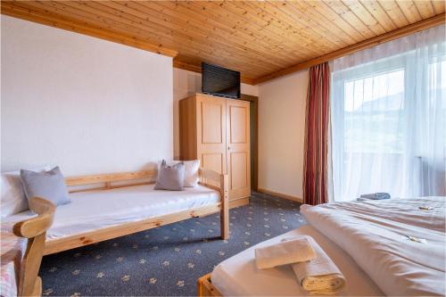 a hotel room with two beds and a window at Panoramahotel Stocker in Pruggern