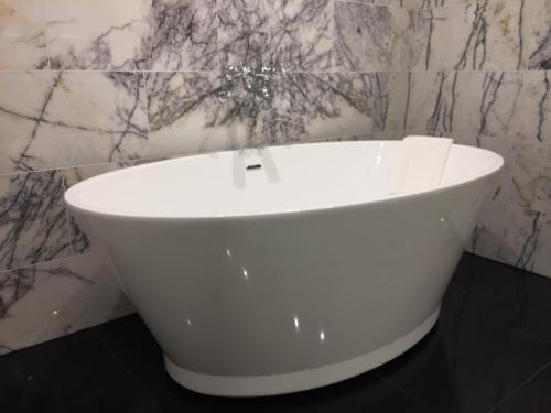 a white bath tub in a bathroom with marble walls at The Wrea Head Hall Country House Hotel & Restaurant in Scarborough