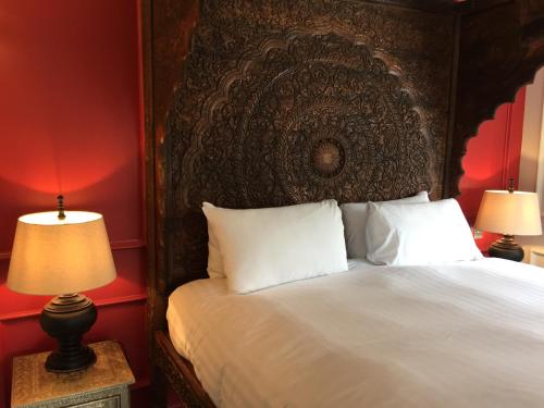 a bedroom with a bed with a large headboard and two lamps at The Wrea Head Hall Country House Hotel & Restaurant in Scarborough