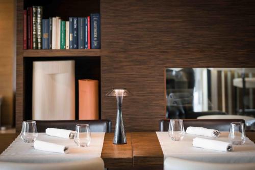 a table with white napkins and a lamp on it at Enjoy Garda Hotel in Peschiera del Garda