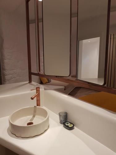 een witte badkamer met een wastafel en een spiegel bij Hotel Gorgona in Mykonos-stad