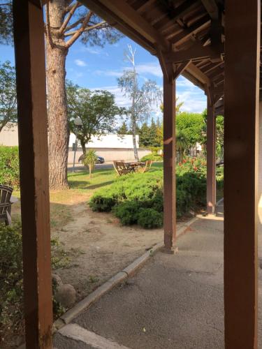 an open porch with a tree in the park at Hotel Cristol in Avignon