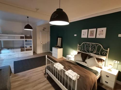 a bedroom with a bed and a green wall at Village Cascais Guest House in Cascais