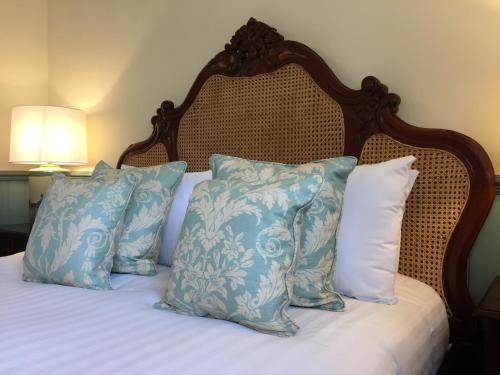 a bed with blue and white pillows on it at The Wrea Head Hall Country House Hotel & Restaurant in Scarborough