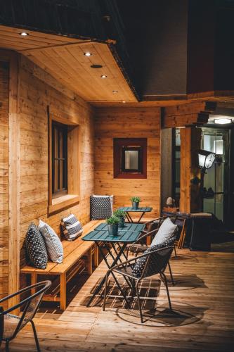 a patio with a table and chairs on a wooden deck at Hotel Sportalm - Adults Only Boutique Hotel in Bad Kleinkirchheim