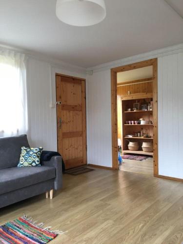 a living room with a couch and a open door at Dom Pod Długim Wiosłem in Wiartel