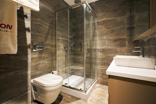 uma casa de banho com um chuveiro, um WC e um lavatório. em Panoramik View Apartment Deluxe Suite em Istambul